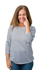 Wall Mural - Beautiful middle age woman wearing stripes sweater over isolated background Pointing to the eye watching you gesture, suspicious expression