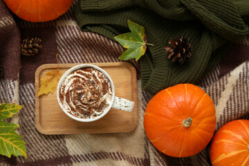 Wall Mural - Autumn composition with cup of cocoa, pumpkins and wooden tray on plaid as background