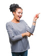© Krakenimages.com - Young braided hair african american girl wearing sweater over isolated background with a big smile on face, pointing with hand and finger to the side looking at the camera.