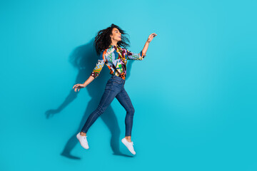 Wall Mural - Photo of cheerful lovely cute girl wear trendy clothes walk look empty space isolated on blue color background