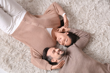 Wall Mural - Young couple lying at home on autumn day, top view