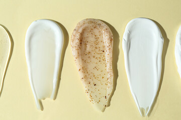 Poster - Smears of different cosmetic products on beige background, flat lay