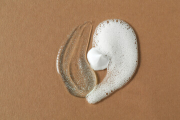 Sticker - Smears of cosmetic products on brown background, top view