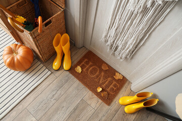 Sticker - Doormat with autumn leaves and gumboots in hallway, top view