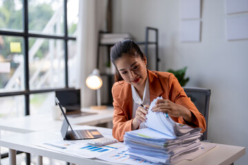 Wall Mural - Businesswoman is searching for a document in a stack of paperwork