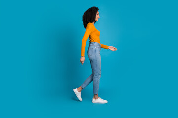 Canvas Print - Full length photo of lovely young lady walking profile empty space dressed stylish yellow garment isolated on blue color background