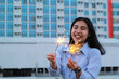 © M Alfan Setyawan - happy asian young business woman holding sparklers to celebrate new year eve standing in outdoor roof top with city building background