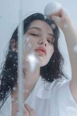 Poster - A woman is standing in front of a mirror with her hair wet. She is holding a white object in her hand