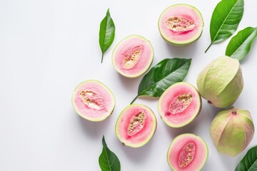 A bunch of pink and green fruit with green leaves. The fruit is cut in half and arranged on a white background