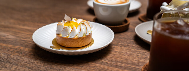 A close up of lemon tart with elegance decoration in a showcase of bakery or coffee shop, concept of sweet and dessert, juicy and freshness, delicious cake, modern and fancy decoration style