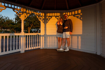 Ocean City, Maryland, USA A couple stand in the setting sun in a small pagoda in the Northside Park.