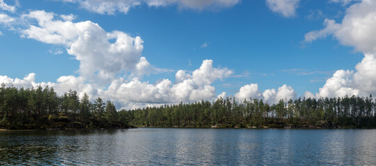 panorama of clouds over forest lake