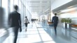 © sungedi - Blurred Silhouettes of Businesspeople Walking in a Modern Office Hallway