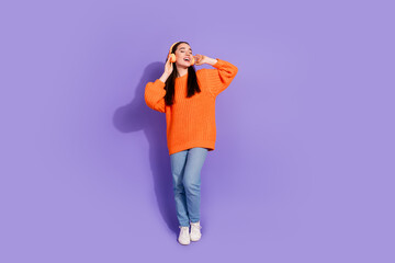 Canvas Print - Photo of cheerful glad girl wear trendy orange clothes enjoy listen music isolated on purple color background