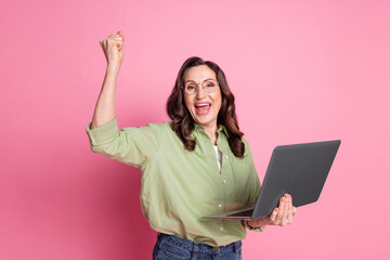 Poster - Photo of experienced retired business lady using laptop raised fist up celebrating good deal ecommerce isolated on pink color background