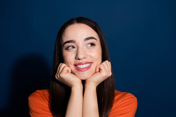 Wall Mural - Photo of lovely pretty cute woman wear orange trendy clothes touch chin look empty space isolated on dark blue color background