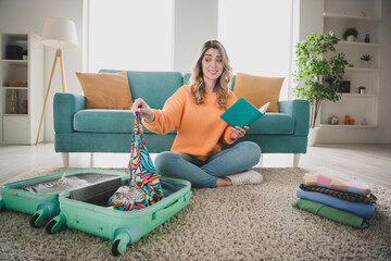 Poster - Full length photo of girl sit floor notebook pack suitcase uncertain dressed orange garment spend pastime spacious house indoors room