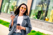 © deagreez - Photo of dreamy lovely girl wear grey trench texting modern gadget enjoying sunny weather beverage outdoors urban city street