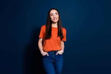 Wall Mural - Photo of dreamy adorable cute woman wear trendy orange clothes look empty space isolated on dark blue color background