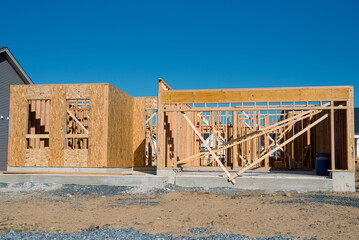 Wall Mural - the beginning of the construction of a plywood house against the blue sky