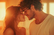 © Spicy World - White heterosexual couple sharing a loving kiss during sunset in a warm, intimate setting indoors
