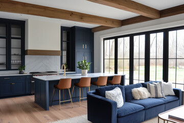 Wall Mural - A white and blue luxury kitchen with chairs sitting at a large island, wood beams on the ceiling, black framed windows, and a blue couch in the living room.