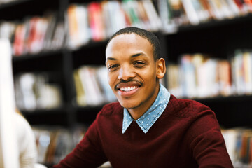 Poster - Education, smile and portrait with man in library for scholarship, knowledge or learning. Research, university and exam with person studying on college campus for project, academy or school resource