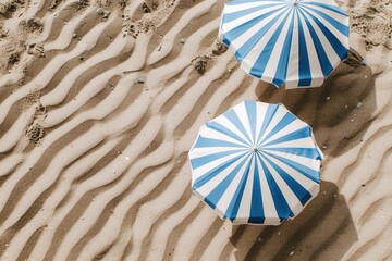 Top view of two striped beach umbrellas, vibrant colors against the sandy beach..