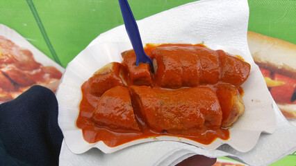 Currywurst purchased from a street vendor in Berlin, Germany, with a fork stuck in it