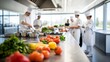 © Elmira - Four chefs work together in a spacious, well-lit kitchen, preparing dishes with fresh vegetables and ingredients laid out on the counter, showcasing teamwork in culinary arts