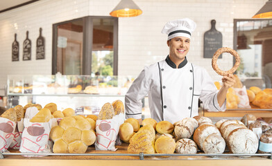 Canvas Print - Young male baker holding a simit