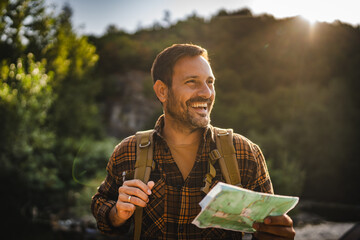 Adult man hiker stand and read map look for the right way