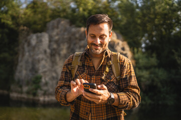 Adult man explore nature while check mobile phone in a serene setting