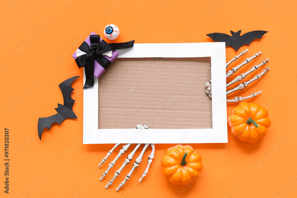 Blank card and Halloween decorations on orange background, top view