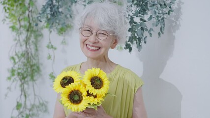 Wall Mural - ひまわりの花束を持つ元気なシニア女性
