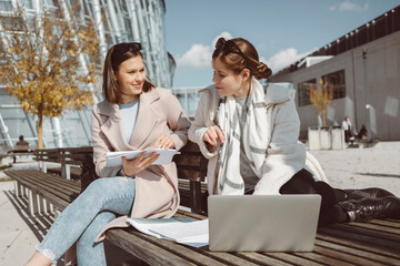 Wall Mural - Two young women, college students, studying together outside