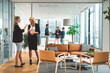 © VisualProduction - Two businesswomen having a discussion in a modern office with glass walls