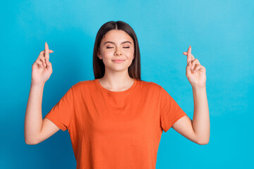 Sticker - Photo portrait of attractive teen woman crossed fingers hope dressed stylish orange clothes isolated on blue color background