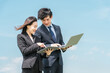 © buritora - 就職・転職・リクルート・青空の中に立つスーツ姿の男女・ビジネスマンとビジネスウーマン