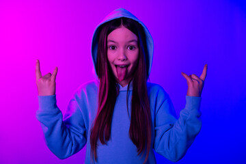 Canvas Print - Photo of cool positive small girl wear hoodie stick out showing hard rock signs empty space isolated neon violet color background