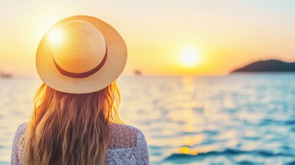 Wall Mural - A woman in a sun hat stands by the water, gazing at the stunning sunset reflecting off the calm sea during a serene evening