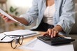 © New Africa - Budget planning. Woman using calculator while working with accounting document at table indoors, closeup
