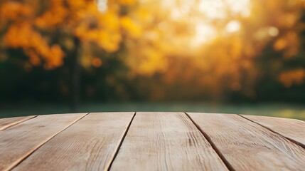 A wooden table with a round wooden top and a view of a tree with orange leaves. The table is empty and the background is blurry