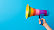 © Pongsatorn - Hands holding a megaphone with rainbow colors, symbolizing LGBTQ