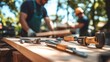 © Ka - A professional carpenter is working with tools on a wooden table. Tools located next to work equipment become a focal point