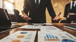 © arhendrix - Business meeting with charts and graphs on the table. Two professionals discuss financial data analysis and strategy development.