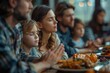 © Katavudh - Detailed image of a family praying before a meal at a church potluck ultra-clear image