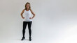 © www.freund-foto.de - Athletische Frau in enganliegendem Sportoutfit. Dynamische Pose auf weißem Hintergrund. Selbstbewusster Blick. Fitness, Gesundheit, Motivation
