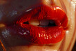© EliteStock - Close-up of a woman's luscious red lips glistening with a glossy finish, showcasing a bold and seductive aesthetic.
