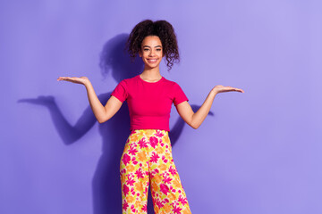 Wall Mural - Photo of cheerful pretty lady dressed pink t-shirt comparing two arms empty space isolated purple color background